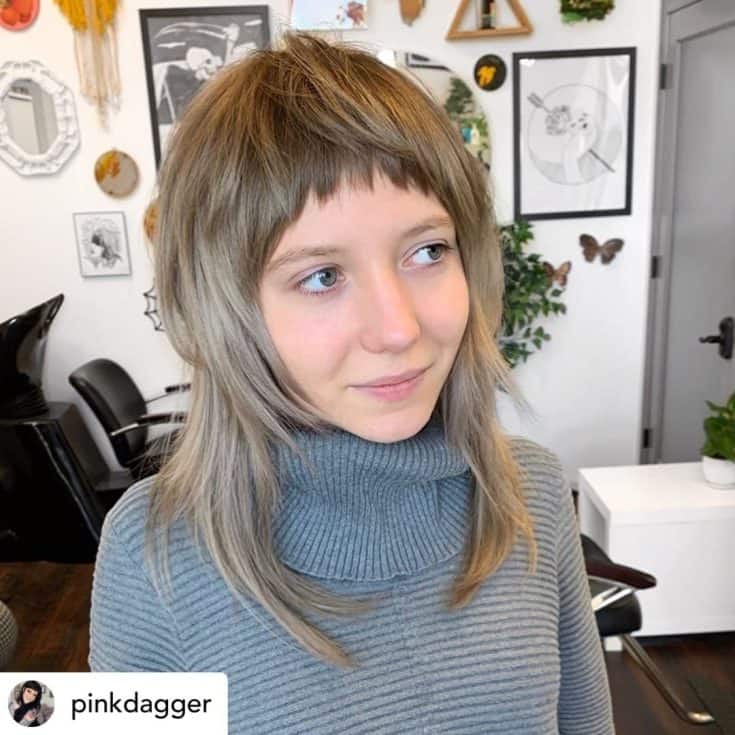 Beautiful woman with shag haircut and baby bangs.