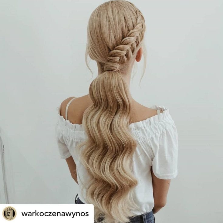 A person with a long, intricate braid hairstyle cascading down their back.