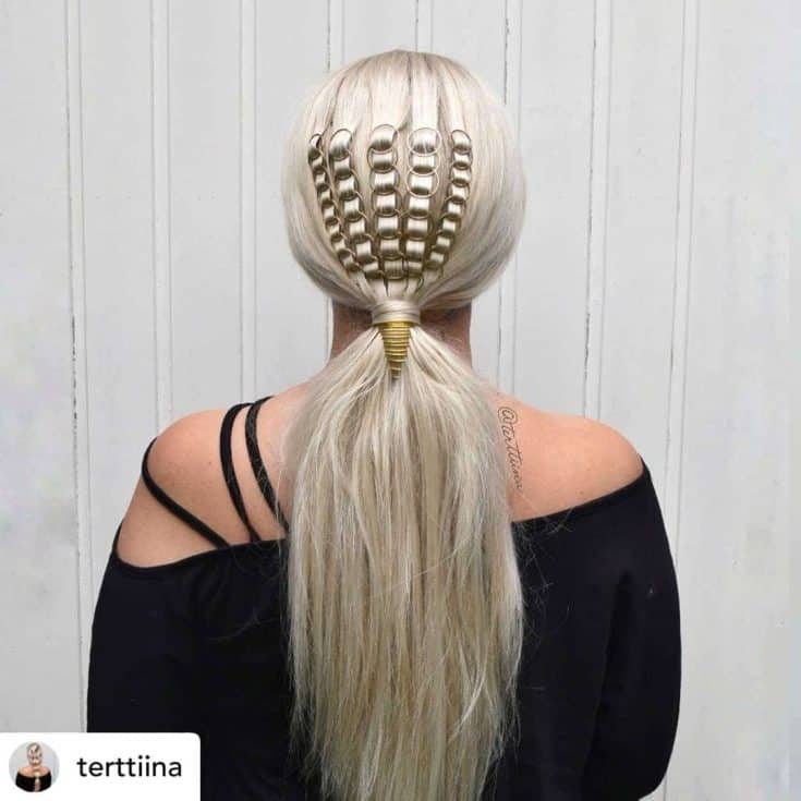 A woman showcasing a unique blonde ponytail hairstyle with a hair accessory resembling a golden shell.