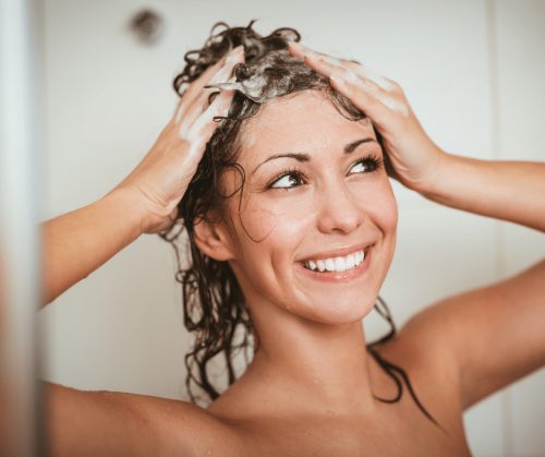 Smiling woman washing her hair.