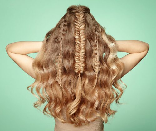 Beautiful fishtail braids on long, wavy blonde hair.