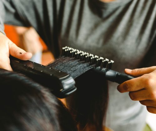 Hair being straightened with a flat iron.