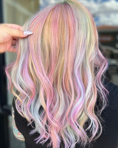 Beautiful pastel rainbow hair color on long wavy hair.