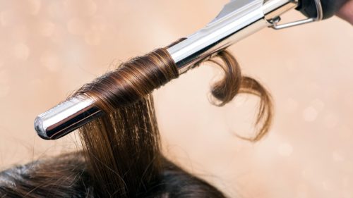 Hair being curled by a curling iron.
