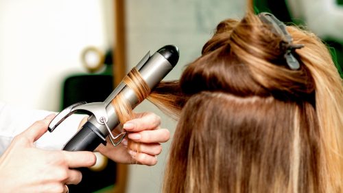 Hair being curled by a curling iron.