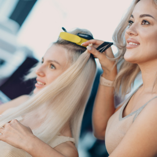 Woman during a hair extension consultation with her hairstylist.