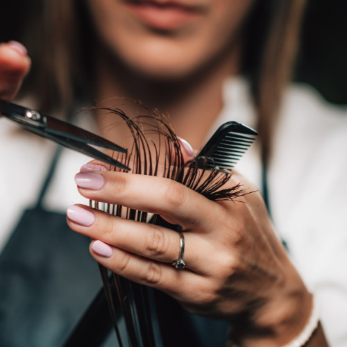 Close up of a woman cutting hair.